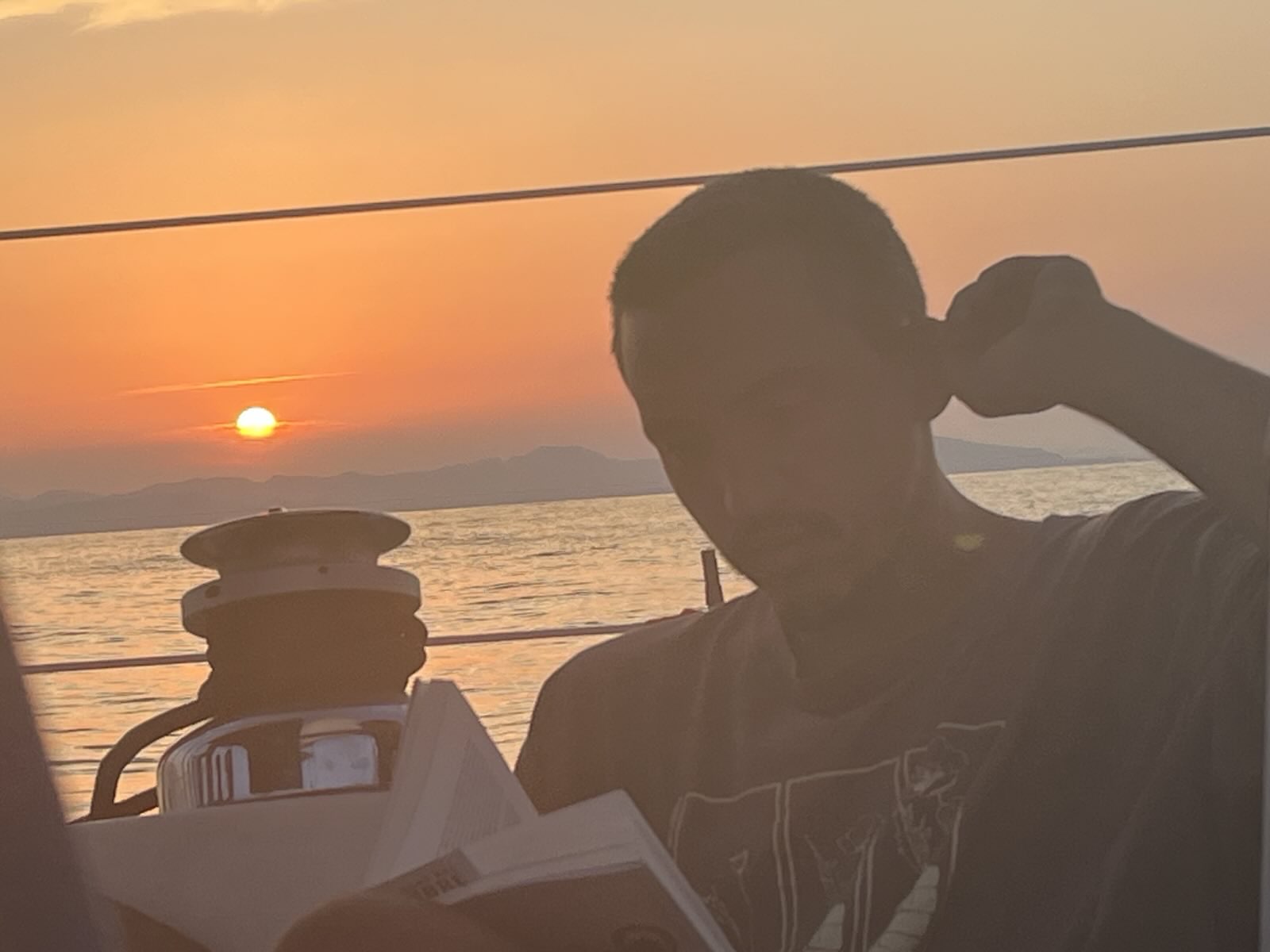 Lucas llegint "Una trenza de hierba sagrada" duant la posta de sol a bord del Yamuna
